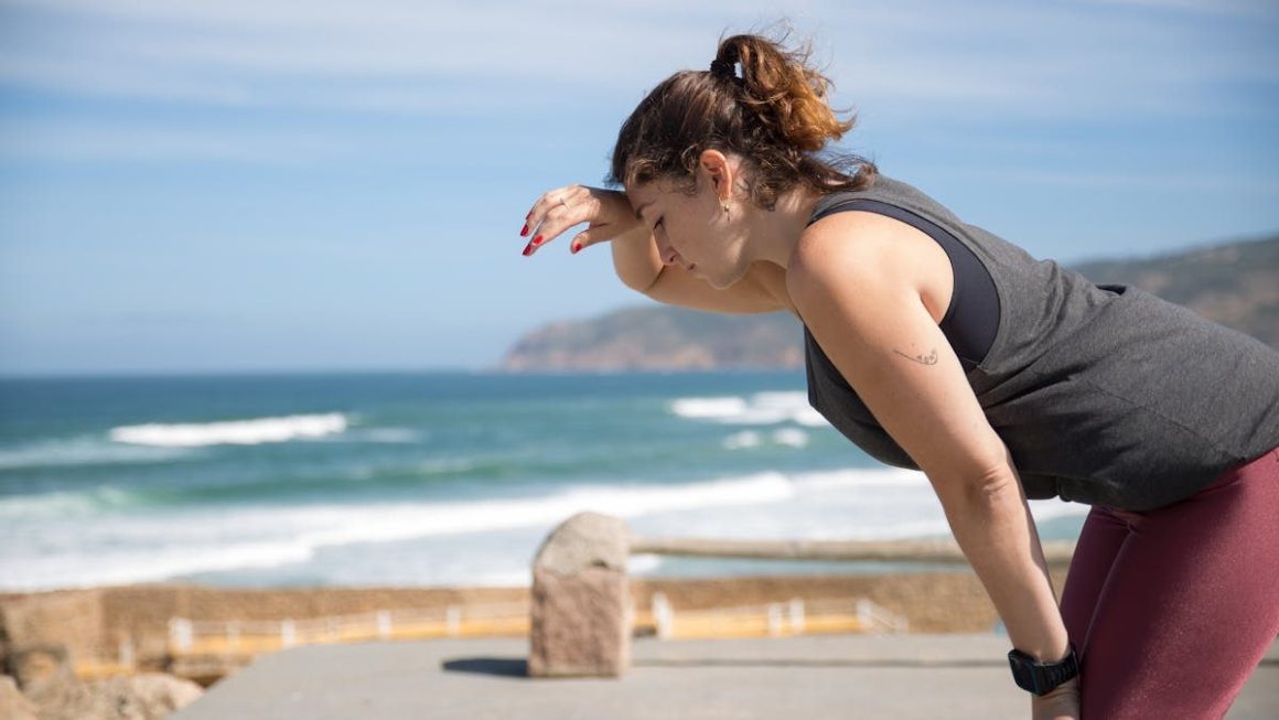 A woman rests after exercise, overlooking the ocean in Portugal's scenic seascape.